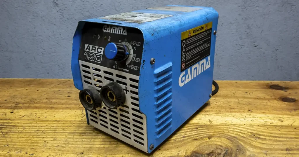 soldadora de marca gamma arc 130 sobre una mesa de madera de un taller