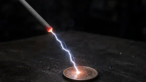 electrodo con rayo saliendo hacia una moneda que esta en una mesa