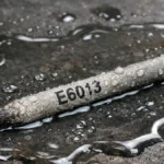 electrodo e6013 sobre una mesa de metal alcanzado por el agua