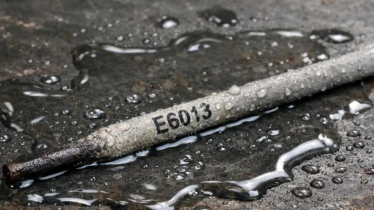 electrodo e6013 sobre una mesa de metal alcanzado por el agua