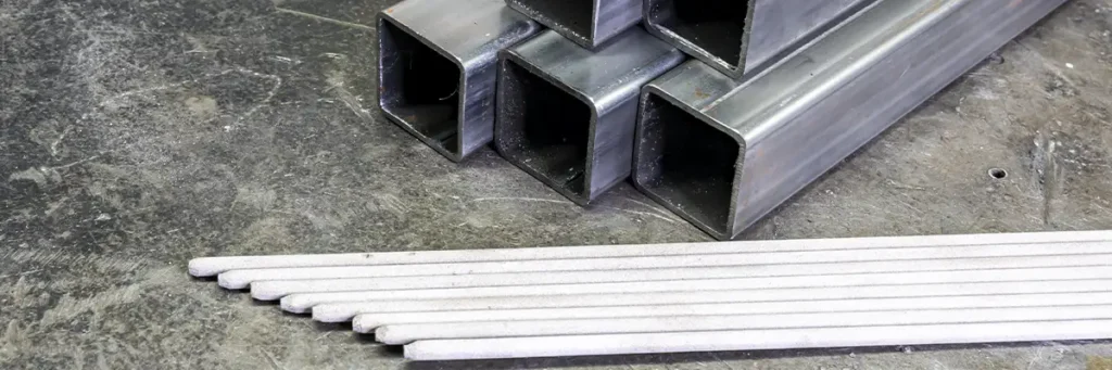 perfiles estructurales al lado de electrodos aptos para soldarlos