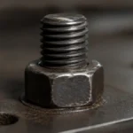 una tuerca ajustada en una varilla roscada ajustando una placa de metal